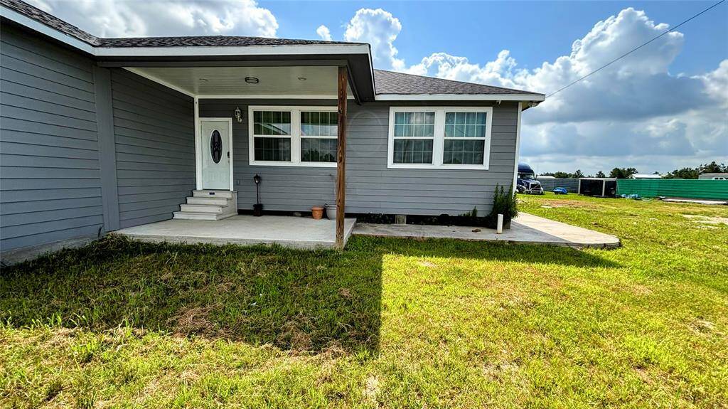 The property is set on a spacious grassy lot, offering ample outdoor space.