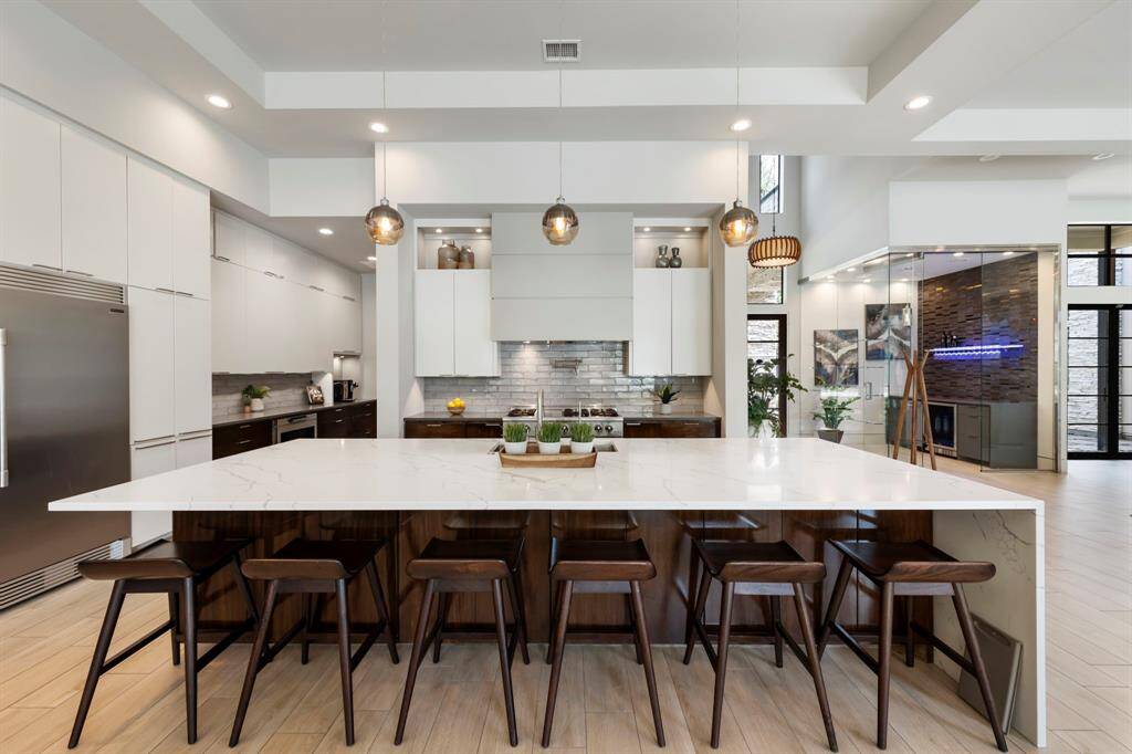 This entertainer’s kitchen stuns with breakfast bar seating, high-end stainless steel appliances, pot filler, pendant lighting, and tons of storage.