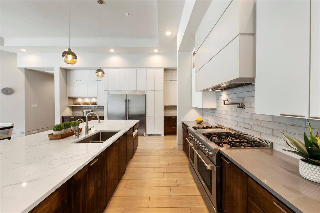 Sleek and sophisticated, this chef’s kitchen features a professional-grade range with pot filler, double ovens, and streamlined cabinetry.