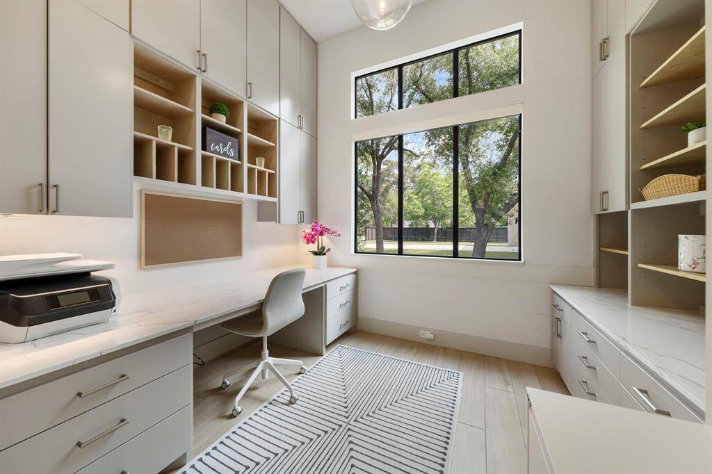 Off the kitchen, a sunlit study or craft room overlooks the front of the home and features custom built-ins and ample storage.