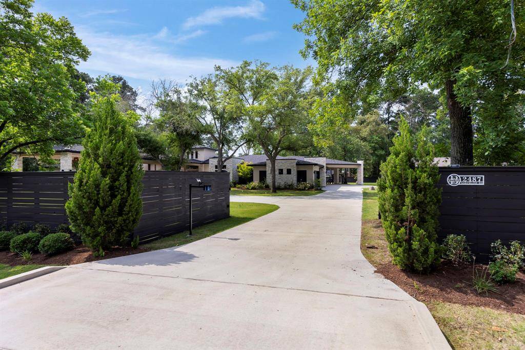 Private gated entrance surrounded by lush, professionally landscaped grounds.