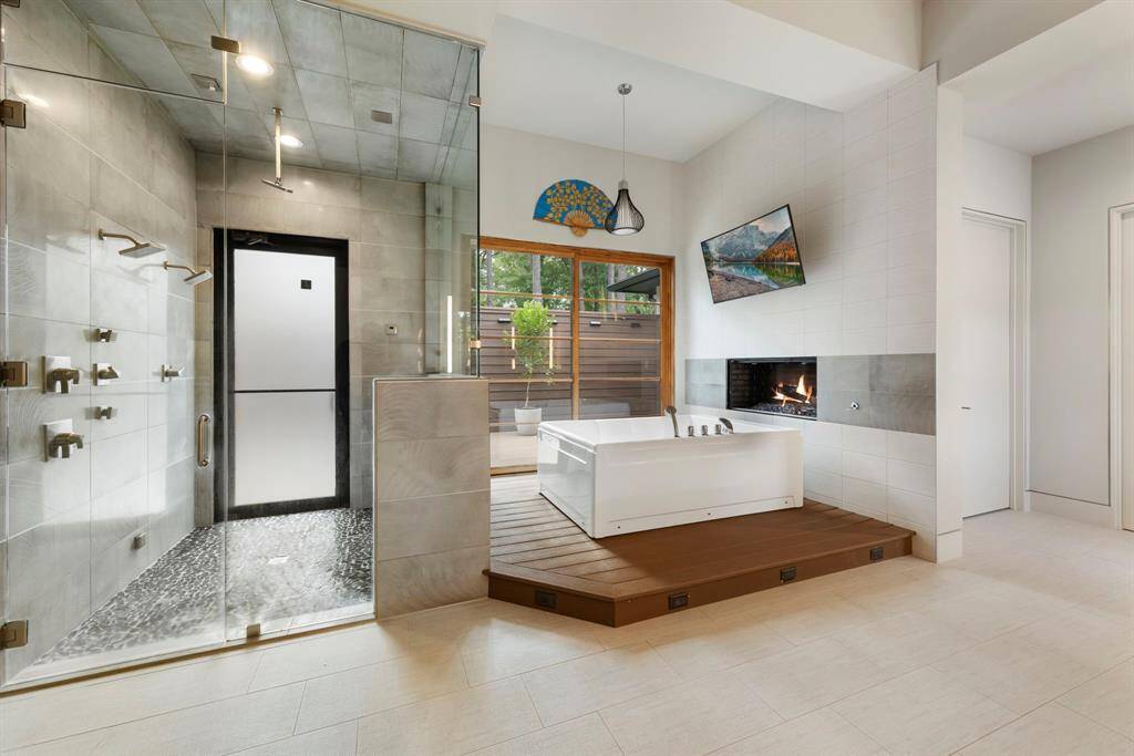 The spa-inspired primary bath impresses with a multi-head walk-in shower, a soaking tub set beside a cozy fireplace, and private patio access—ideal for a serene wellness retreat. Ample space to add a cold plunge, sauna, and more.