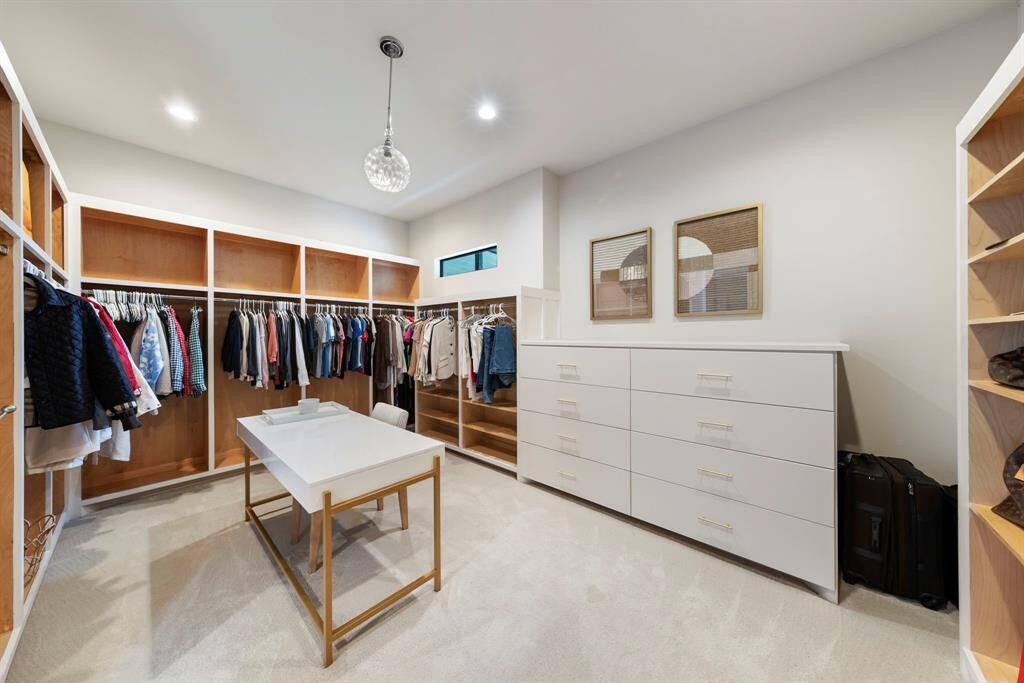 This elegant walk-in closet features custom cabinetry and abundant storage—blending functionality with boutique-inspired style.