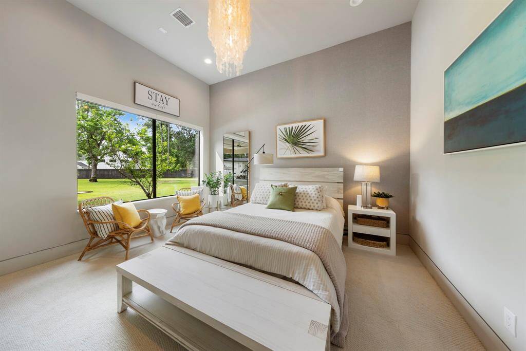 Soft neutrals, layered textures, and a stunning view to the lush backyard create a peaceful guest retreat that feels like a staycation every time.