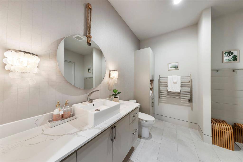 With soft lighting and modern fixtures this en-suite bathroom exudes spa-like serenity and timeless style.