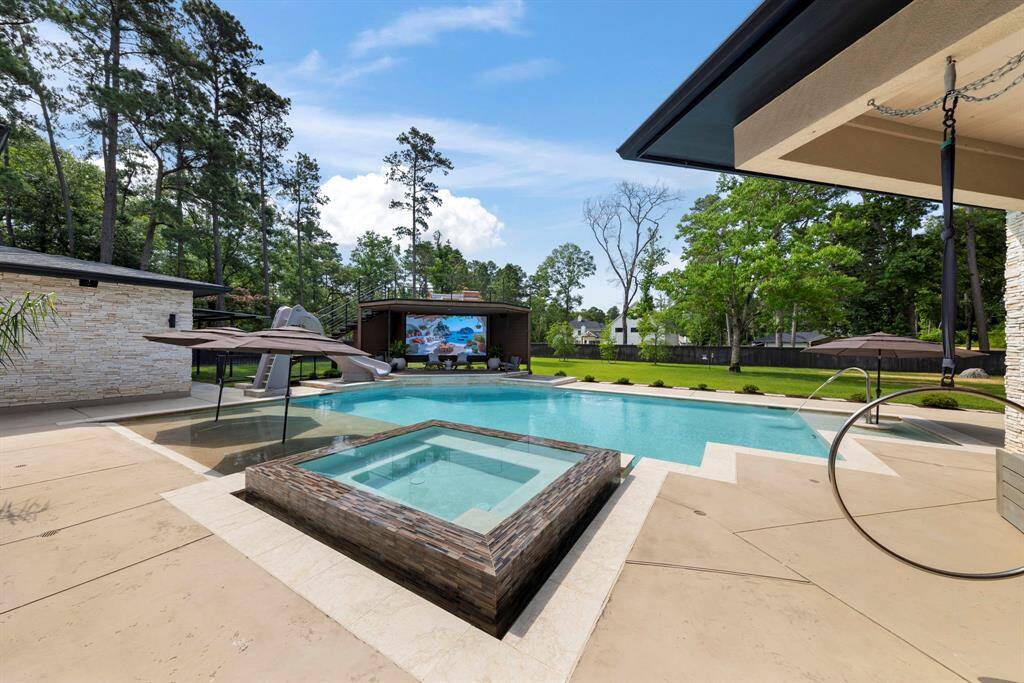 Resort-style backyard retreat with a sparkling saltwater pool/spa, waterslide, sun shelf with in-water umbrella mounts and two-story deck with high-end media screen.