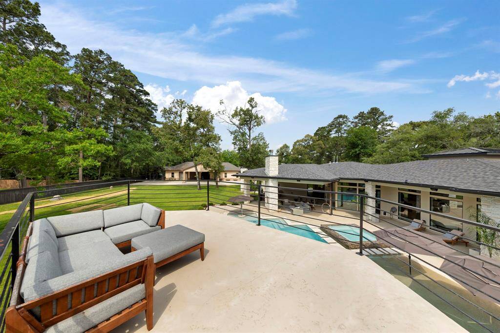 Perched above the pool, the elevated rooftop terrace offers a private vantage point with panoramic views of the lush, tree-lined property.