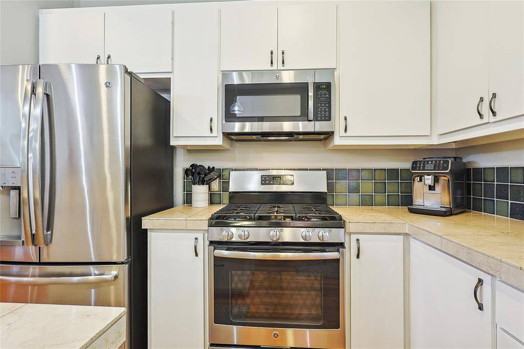 The arched window provides ample natural light and a great view of trees from the sink
