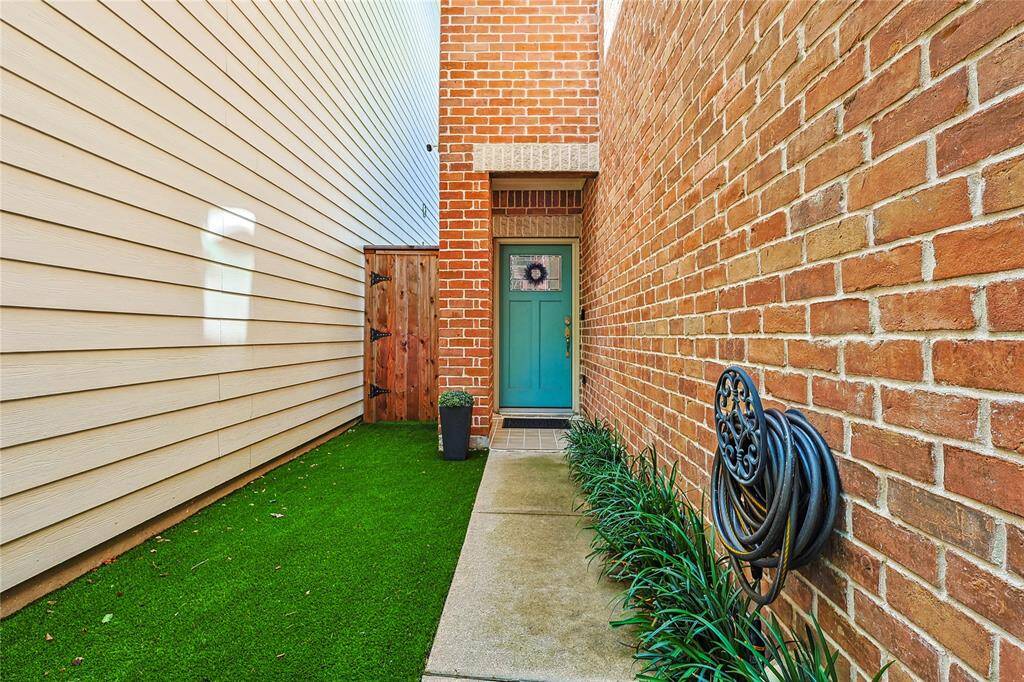 Walkway leading to a welcoming front door with low-maintenance turf and garden bed