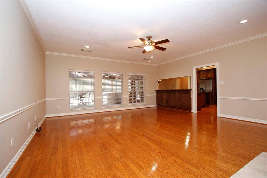 This spacious family room is the hub of the home.  Three large windows showcase your large covered patio & back yard.  To the right is your kitchen area with a convenient pass-through, ideal for entertaining.