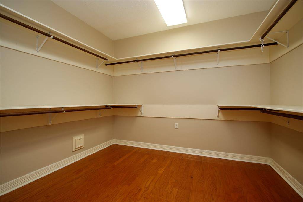 Very spacious walk-in closet with ample shelving, upper & lower hanging space.