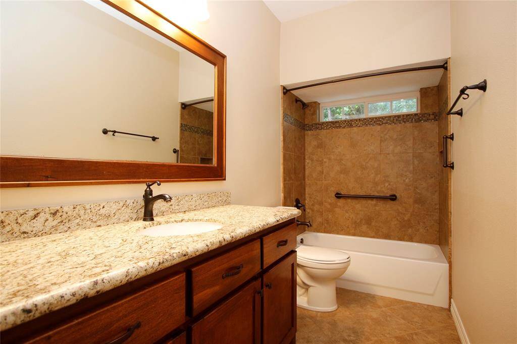 Secondary bathroom #1 separates secondary bedrooms 1 & 2.  Custom framed mirror, granite counters, and tiled shower/tub combo -- also has storage closet just to the left as you enter bathroom.