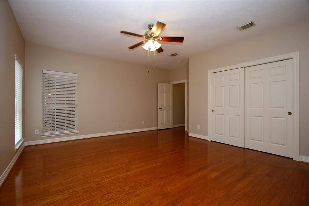 Another view of the third secondary bedroom that shows another large closet that spans the width of the wall and a window that looks out to the covered patio.