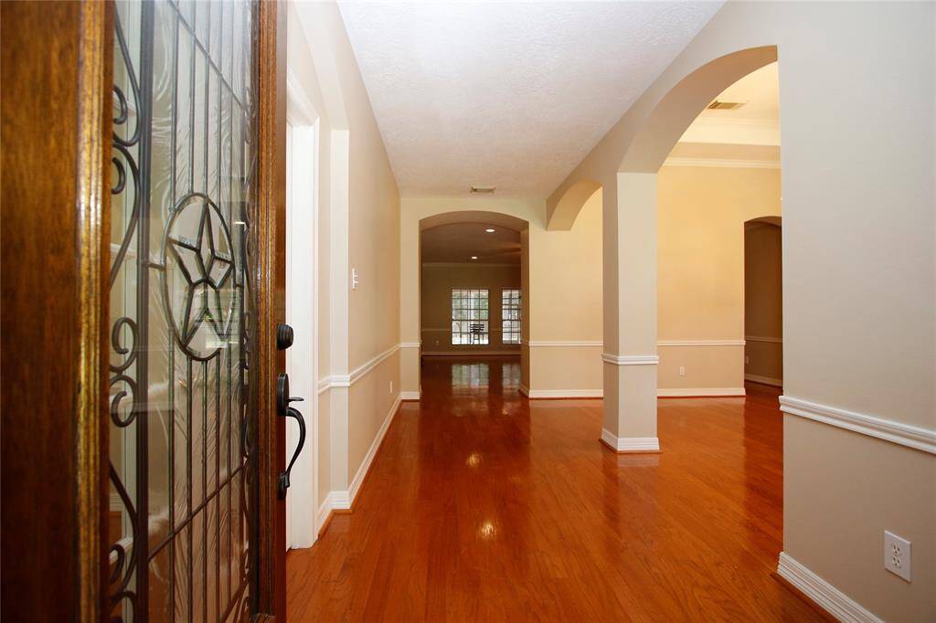 Step right in to the large entryway, warm wood flooring, elegant archways, and neutral walls. The open design, tall ceilings & large windows provide an inviting atmosphere.