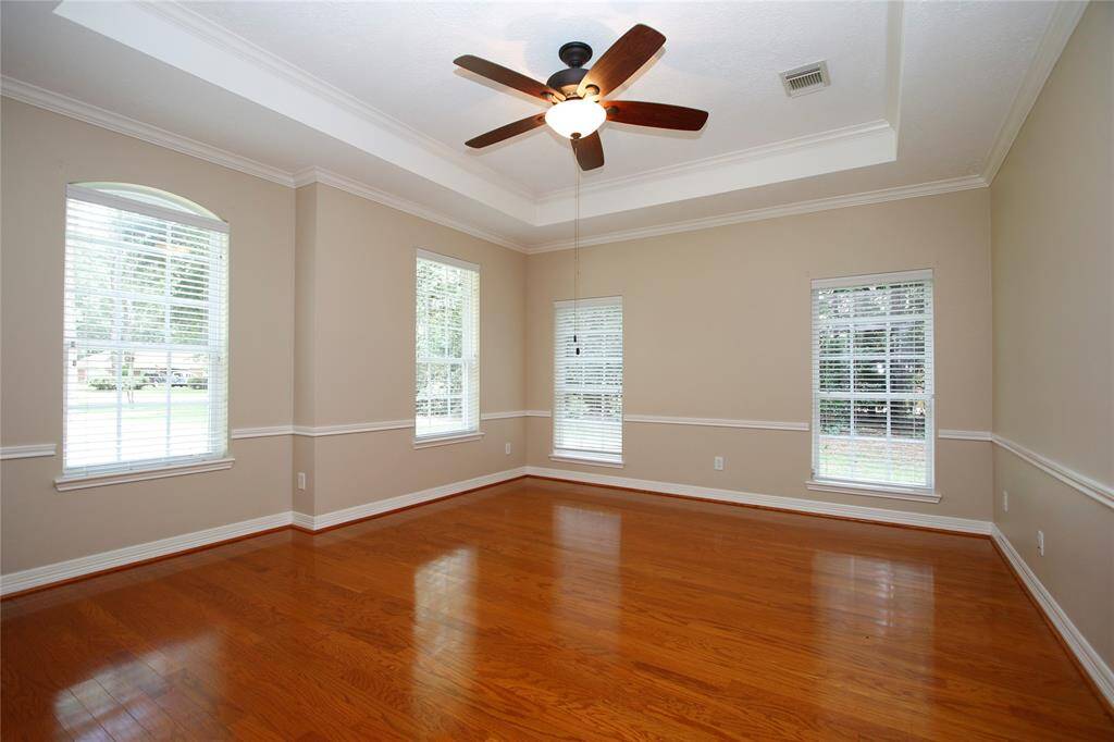 The office provides all the space you need for your home office.  It features crown molding, chair rail and a tray ceiling with a ceiling fan. Abundant natural light enters through multiple large windows with white blinds, creating a bright and airy atmosphere.