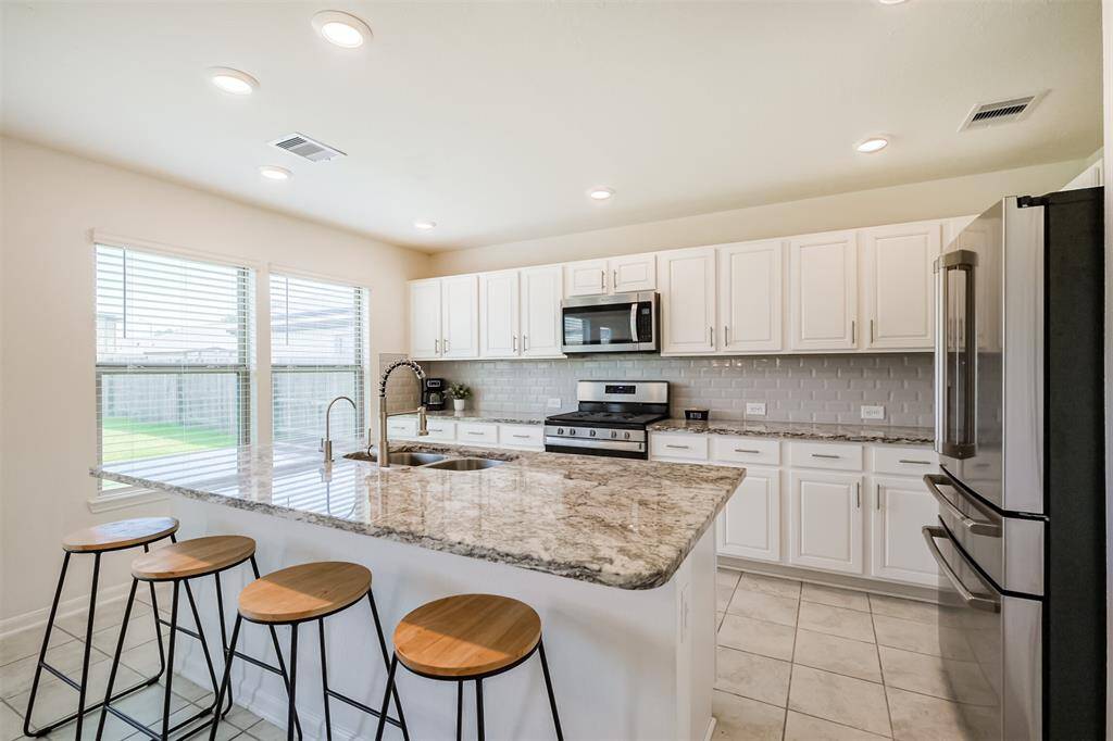 Take in another angle of your future kitchen. With  white cabinetry and stainless steel appliances , this space is designed to make cooking feel effortless.