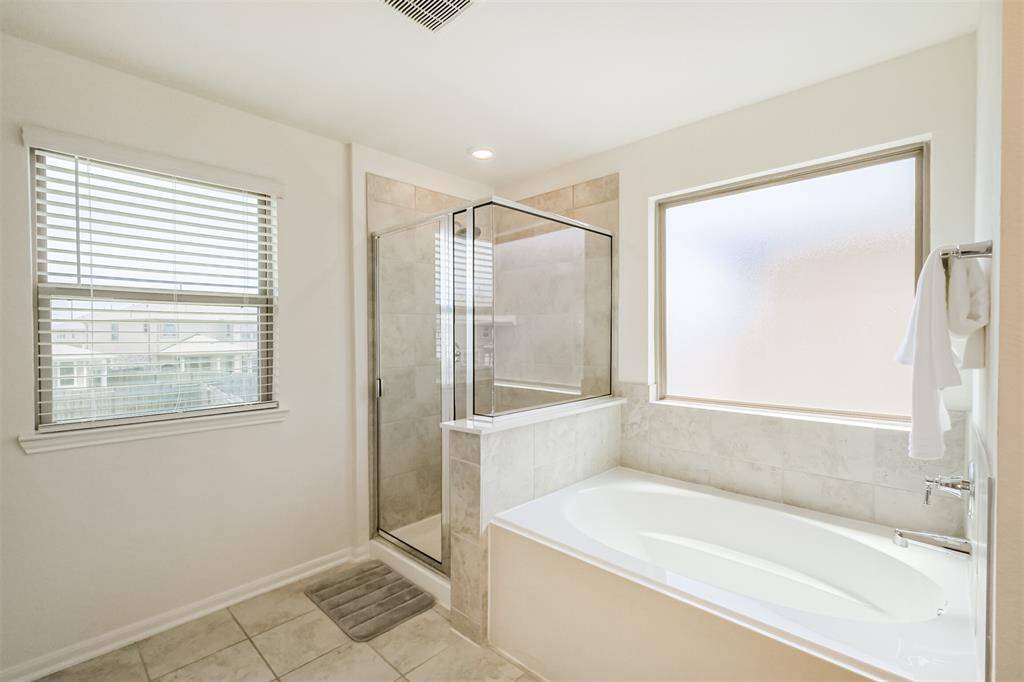 This primary bathroom offers both a relaxing tub and a spacious separate shower. It's designed to give you the luxury you deserve, right at home!