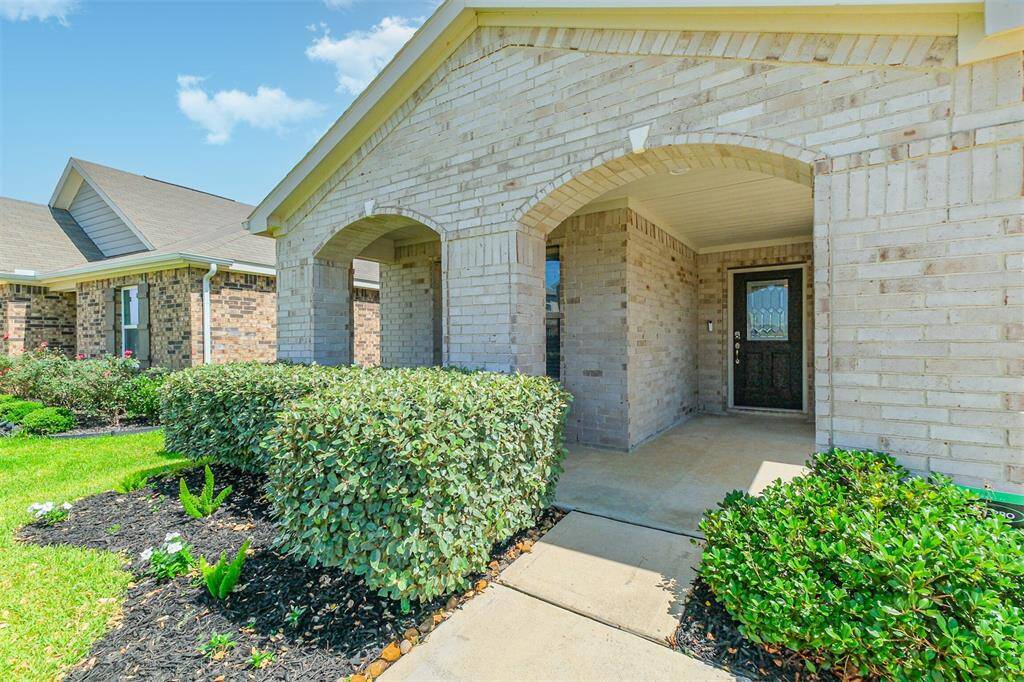 Modern two-story home with tidy front lawn, and a welcoming covered entrance.