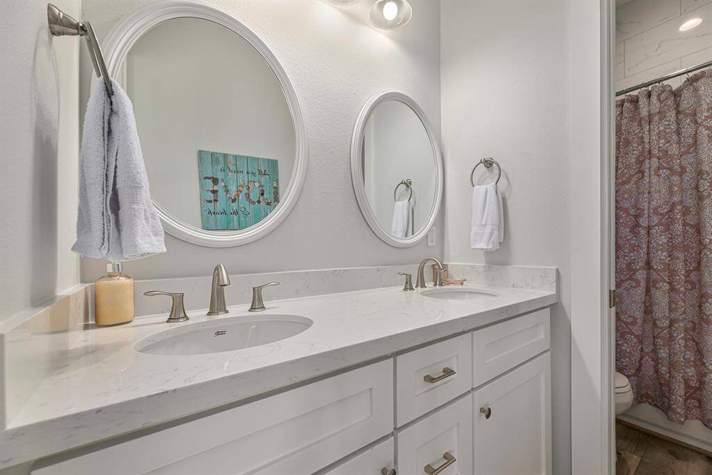 A double sink bathroom attached to the four bunk room. Pocket door separates the toilet and the shower.