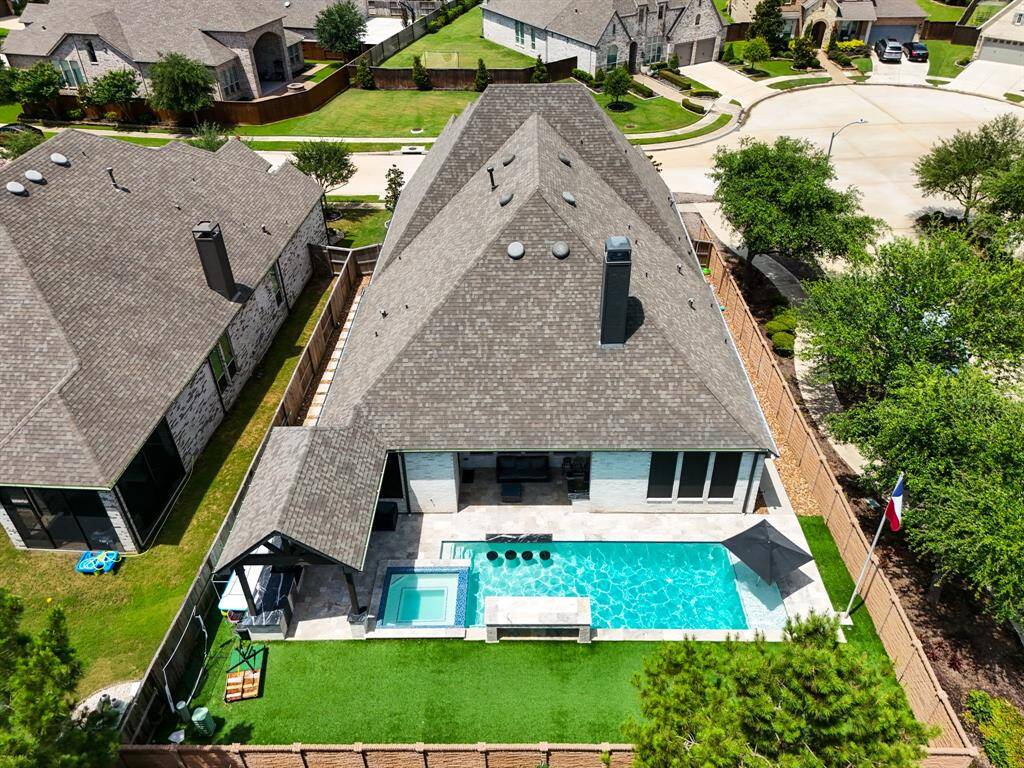 A bird’s-eye view of this corner lot highlights the private pool and spa, with neighborhood walking trails just steps away—perfect for relaxing at home or enjoying the outdoors.
