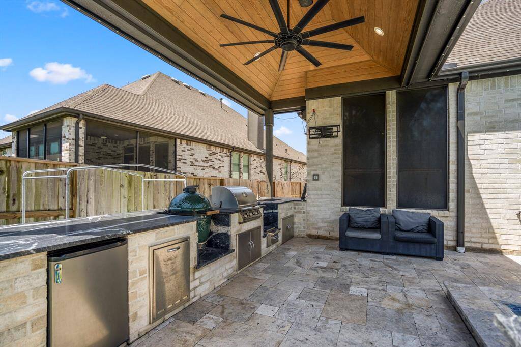 The expansive covered patio is designed for year-round enjoyment! The kitchen boasts a built-in gas grill, additional sink, granite countertops, a fridge, and plenty of prep space—perfect for entertaining or relaxing in style.