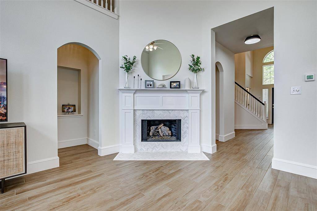 A romantic gas-log fireplace serves as the focal point of the room, surrounded by elegant tile and a beautiful wooden mantel, making it the perfect spot to relax and unwind.