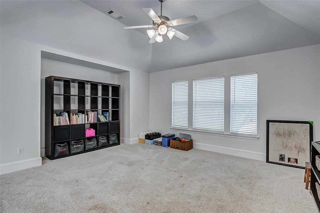 The oversized game room is a true highlight of the second floor, offering an expansive & versatile space for all kinds of activities. The high vaulted ceilings, complemented by a ceiling fan, create a grand, airy atmosphere, while the large windows fill the room with an abundance of natural light, enhancing the open feel.