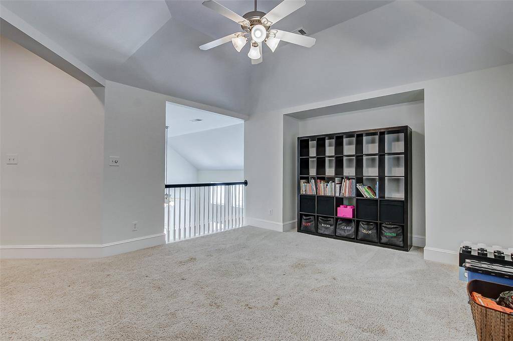 Plush carpeting adds warmth and comfort, making it an inviting spot for lounging or entertaining. Additionally, the room includes a thoughtfully designed entertainment nook, perfect for a media center or gaming setup, making this space ideal for family gatherings, movie nights, or recreational activities.