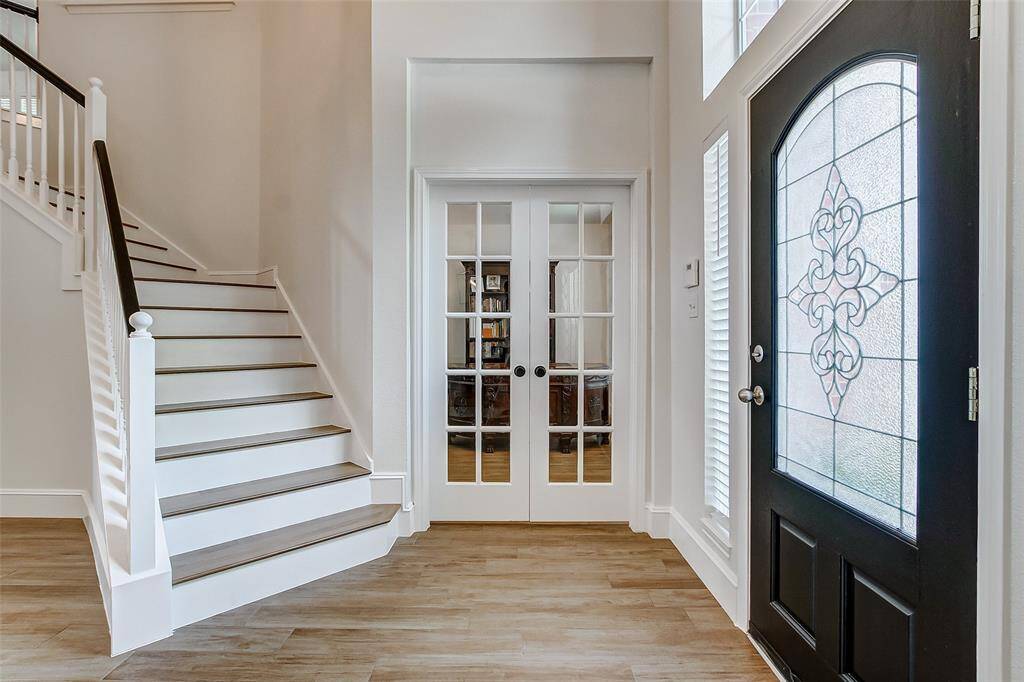 To the right of the entry, you'll find a spacious and private home office tucked behind elegant French doors. A stunning wooden staircase leads to the second floor, where three generously sized secondary bedrooms and a large game room await.