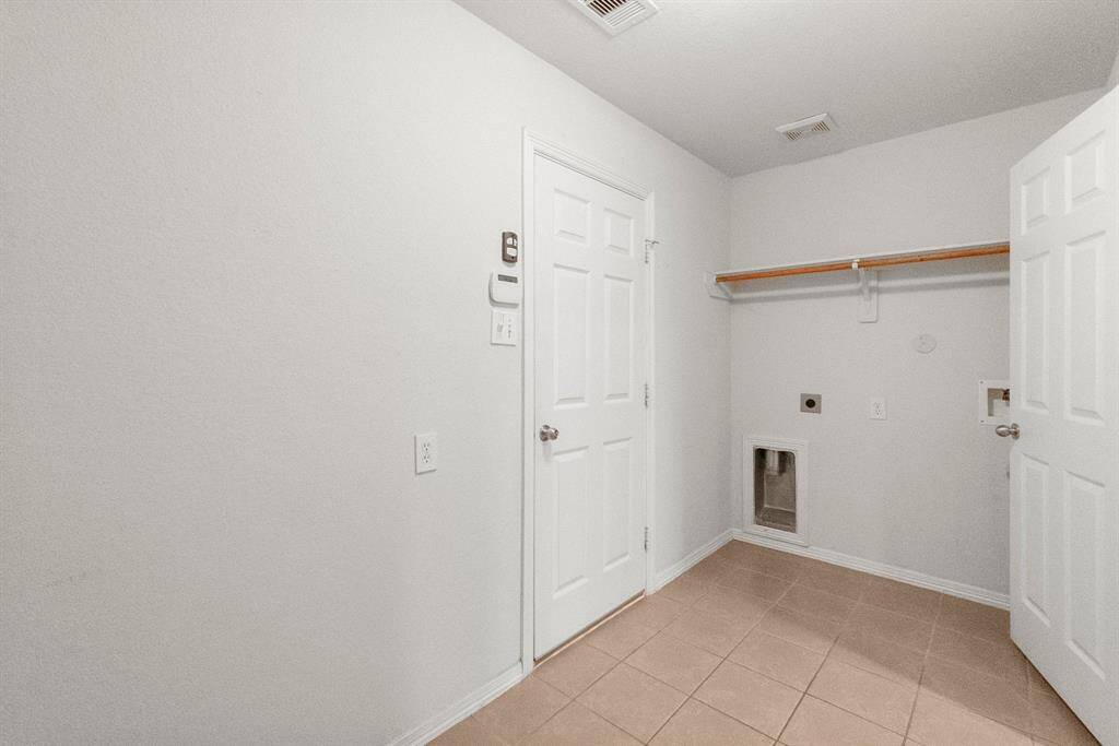 Large utility room that has electric dryer hook up and extra space for storage.