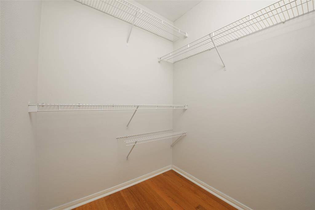This walk-in closet off the primary bedroom offers multiple tiers of built-in wire shelving, making wardrobe organization a breeze. With plenty of vertical space and solid wood floors, it’s the ideal closet for maintaining order and accessibility.