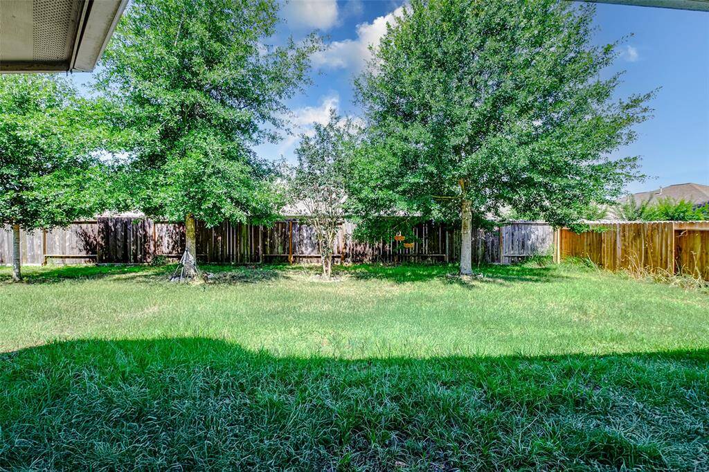 Centrally positioned shade trees define this peaceful backyard oasis. The fully fenced yard offers privacy and safety for pets or playtime, while the deep lot ensures there’s ample room for gardening, lounging, or future landscaping dreams.