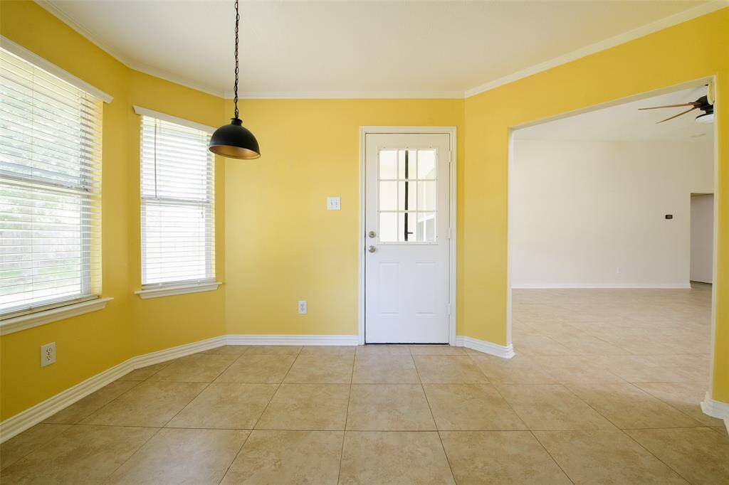 This spacious open-concept layout features a large breakfast area that flows effortlessly into the living space. Whether you’re hosting family meals or working from home, the abundance of windows and open archway make this area feel bright, connected, and functional.