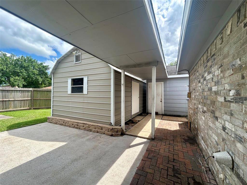 Covered walkway to garage and workshop.
