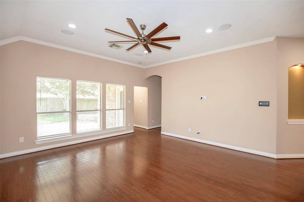 The spacious family room is filled with natural light from three large windows that offer a clear view of the patio.