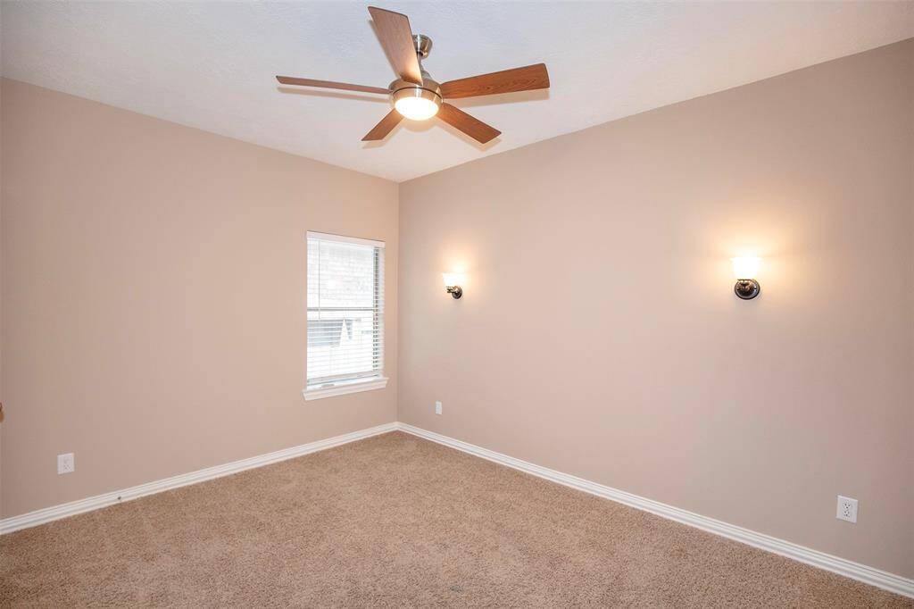 This secondary bedroom has marvelous wall sconce lighting and ceiling fan.