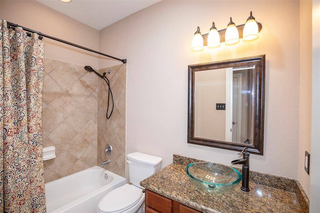 The guest bathroom features a vessel sink set on a granite countertop.