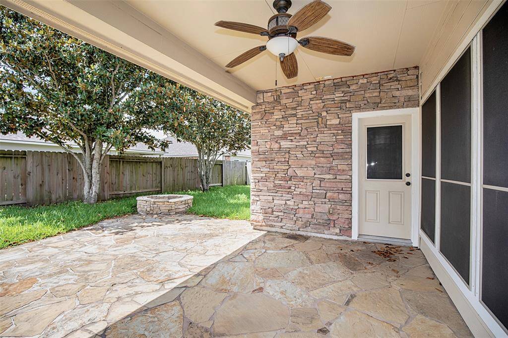 Step outside to the inviting covered patio, where a beautiful stone accent wall adds warmth and charm.