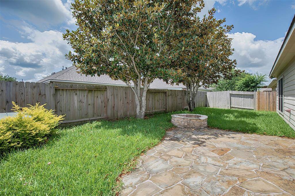 Just beyond, the backyard features a cozy fire pit—ideal for cool evenings.