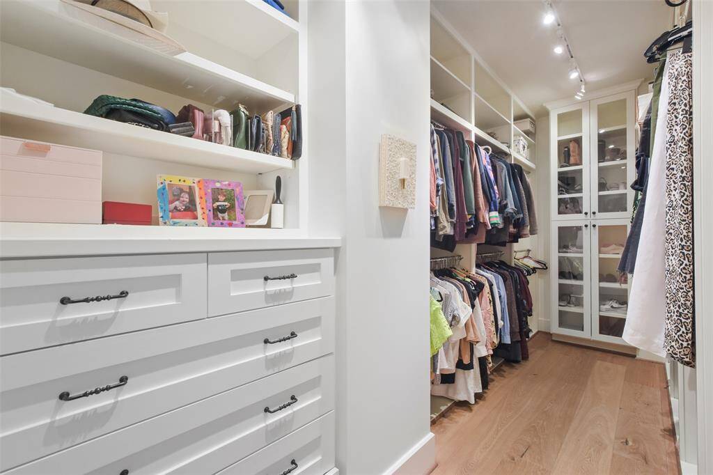 The Primary bedroom boasts two walk-in closets. One of two walk-in closets is a dream space, thoughtfully designed to combine elegance with functionality. Expansive and well-organized, it features custom-built shelving, hanging rods, and drawers that maximize storage for clothing, shoes, and accessories. Soft lighting illuminates every corner, highlighting the beautifully crafted finishes and ensuring items are easy to find.