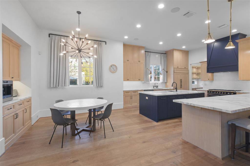 The breakfast nook, bathed in natural light from nearby windows, offers the perfect spot for casual dining or morning gatherings. Adding a touch of convenience and charm, a built-in coffee bar is tucked nearby, complete with a dedicated space for your coffee maker, and ample storage for all your brewing essentials.