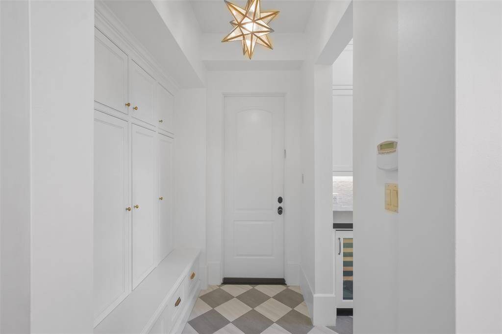 The stylish mudroom with built-in cabinets for convenient storage and bench doubling as a seating area for functionality.