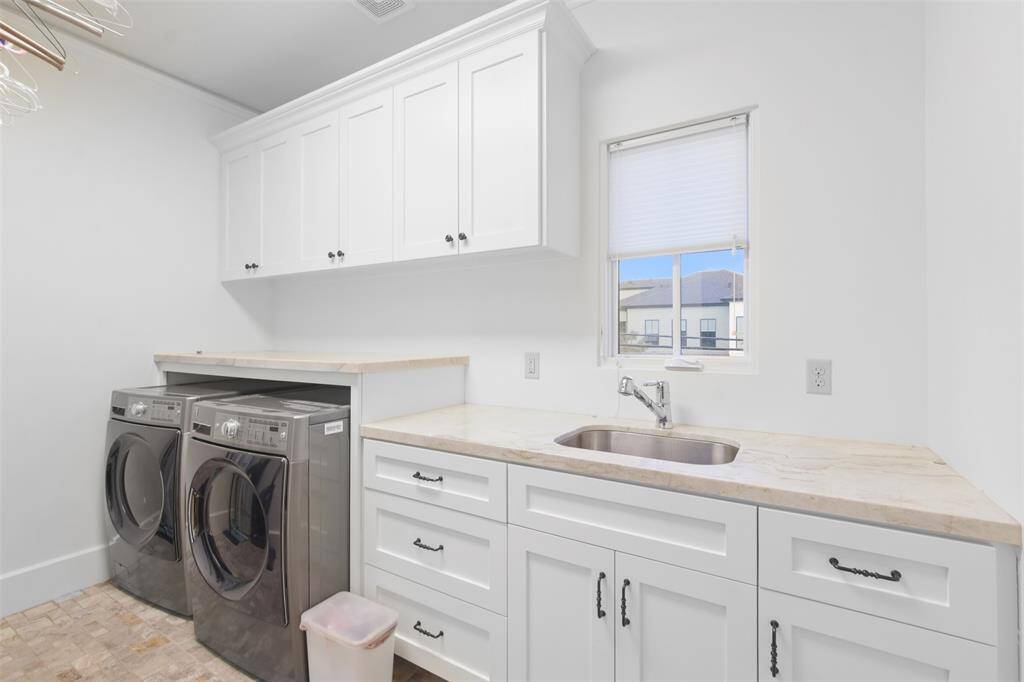 Custom cabinets provide ample storage for detergents, cleaning supplies, and linens, keeping everything within easy reach and great counter space make doing laundry seem effortless.