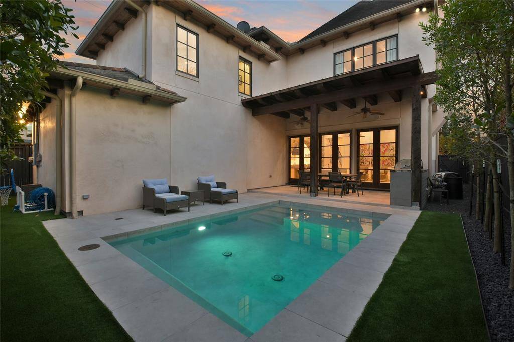Relax and entertain in this backyard that offers a sparkling pool with space for lounging, a covered area with ceiling fans, surround sound speakers and a cooking space that features a built-in grill making it effortless to prepare meals al fresco. This inviting space is perfect for hosting poolside gatherings or enjoying quiet evenings under the stars.