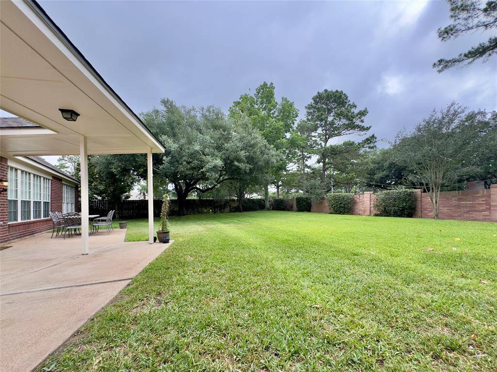 Backyard w/ extended patio flatwork. Covered walkway from home to garage.