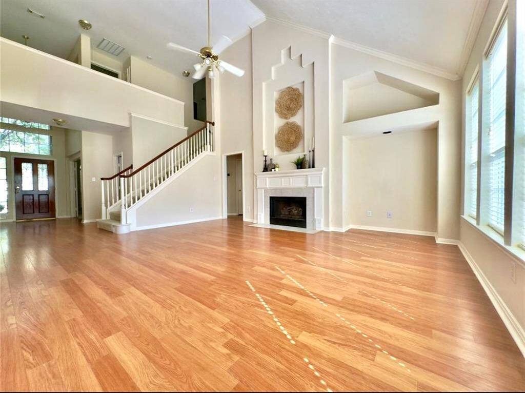 Family Room with soaring Cathedral, ceiling, gas, fireplace, entertainment niche, and wall of windows.