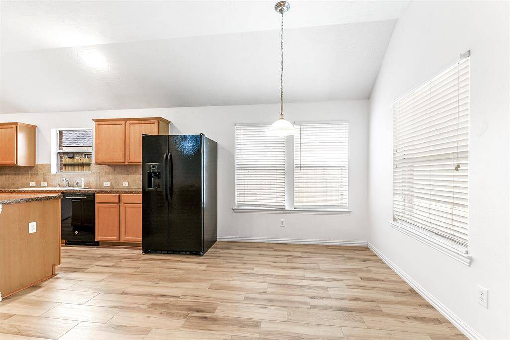 The kitchen opens to the breakfast space and living room. Notice the large window that provides a view of the covered patio, offering easy access from the kitchen to the backyard. This home is perfect for entertaining."