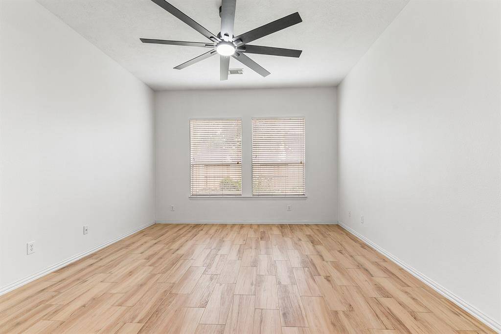 Another view showcases the spacious room with high ceilings and beautiful backyard views.