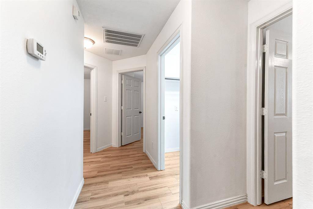 The main floor hallway leads to the three guest bedrooms, the main floor guest bathroom, and the utility room with access to the garage.