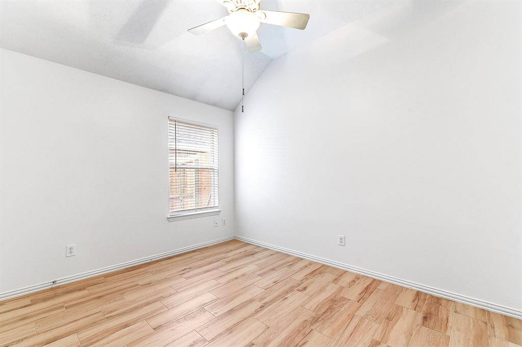 The oversized secondary bedrooms each feature spacious layouts, high ceilings, and closet space for storage. All rooms are equipped with ceiling fans and showcase the same wood-look tile flooring found throughout the home.
